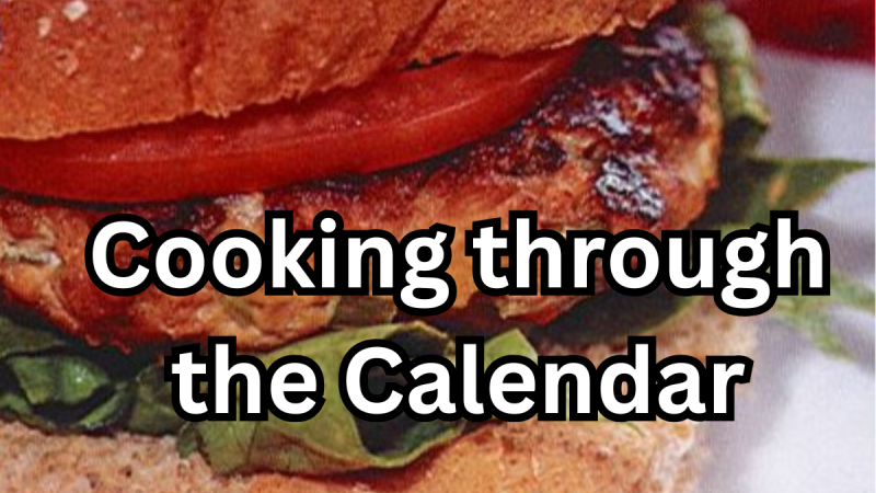 Chicken Burger in background - Cooking through the Calendar written on top